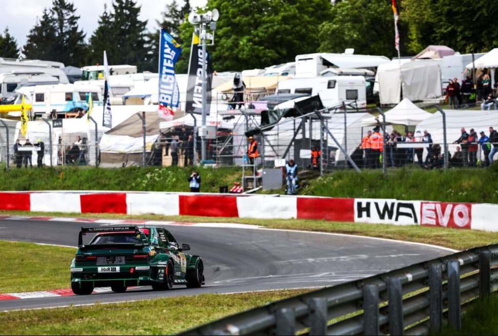 HWA EVO.R in einer Kurve der Nürburgring-Nordschleife mit Zuschauern im Hintergrund